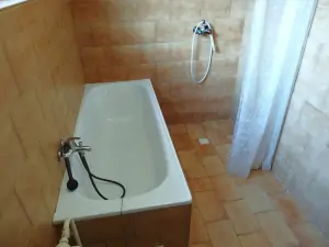 koupelna je vybavena vanou, ruční sprchou a umyvadlem