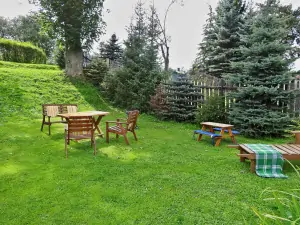 na zahradě je k dispozici venkovní posezení, ohniště, přenosný gril a houpací lavice