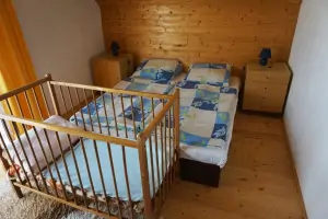 ložnice v podkroví se sedacím koutem, 2 lůžky a dětskou postýlkou