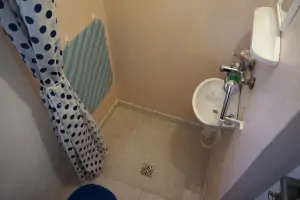 malá koupelna se sprchovým koutem (ruční sprchou), umyvadlem a WC