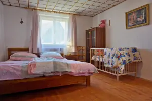 ložnice s dvojlůžkem, dětskou postelí, dětskou postýlkou a krbovými kamny v podkroví