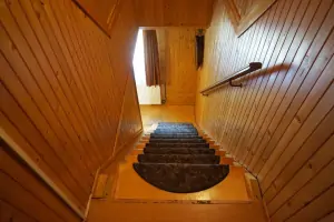 z obytné místnosti z kuchyňského koutu vedou schody do podkroví