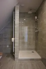 koupelna v podkroví se sprchovým koutem, umyvadlem a WC