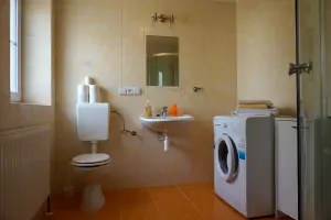 koupelna se sprchovým koutem, umyvadlem, WC a pračkou v prvním patře (součást apartmánu)