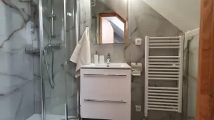 koupelna se sprchovým koutem, umyvadlem a WC v podkrovním pokoji s dvojlůžkem