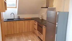 pokoj s dvojlůžkem, kuchyňským koutem a koupelnou v podkroví