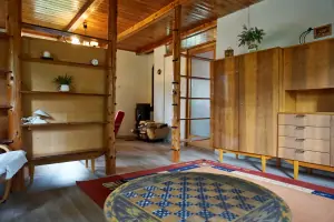 obývací místnost s křesly, krbovými kamny a rozkládacími gauči