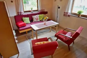 obývací místnost s křesly, krbovými kamny a rozkládacími gauči
