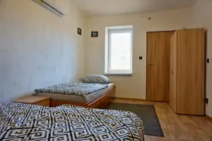 ložnice s dvojlůžkem, lůžkem a klimatizační jednotkou