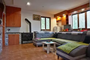 obývací místnost se sedací soupravou (možnost spaní pro 2 osoby), krbovými kamny, TV a jídelním a kuchyňským koutem