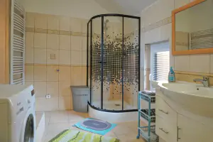 koupelna se sprchovým koutem, vanou, dvojumyvadlem, pračkou a WC