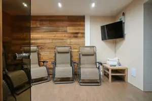 odpočinková místnost s finskou saunou, lehátky, sprchovým koutem a TV