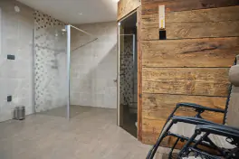 odpočinková místnost s finskou saunou, lehátky, sprchovým koutem a TV