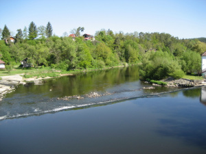 Pohled na chatu z mostu přes řeku Otavu