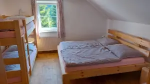 ložnice s dvojlůžkem, patrovou postelí a přistýlkou v prvním patře