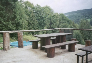 U chalupy se nachází terasa s venkovním posezením a za ní bazén (průměr 3 m)