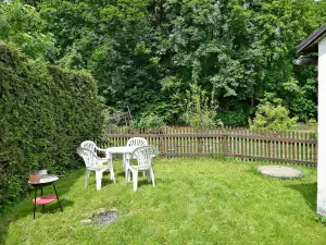 Na malé zahradě za chalupou je k dispozici zahradní nábytek (další stoly a židle jsou uschovány v kůlně), přenosný gril a ohniště