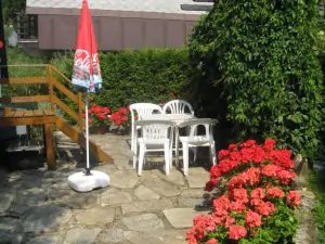 Za chatou se nachází zahradní nábytek se zahradním krbem (léto)