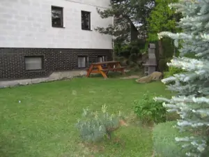 Na zahradě u domu se nachází venkovní posezení a zahradní krb