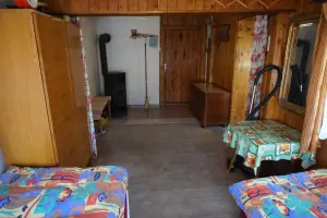 ložnice v přízemí se 2 lůžky, rozkládacím gaučem pro 1 osobu a kamny