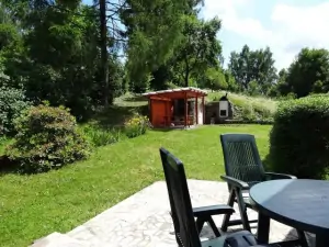 Před chatou se nachází terasa se zahradním nábytkem