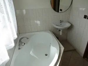 koupelna s vanou, umyvadlem a WC v podkroví 