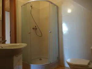koupelna se sprchovým koutem, WC a umyvadlem v podkroví