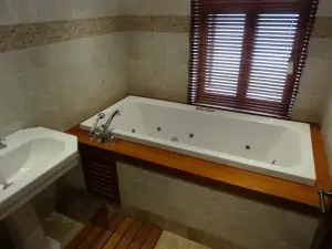 koupelna s hydromasážní vanou a umyvadlem