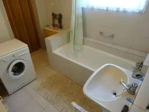 koupelna s vanou, pračkou, umyvadlem a WC