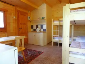 zahradní chatka - pokoj s 2 patrovými postelemi a malým kuchyňským koutem