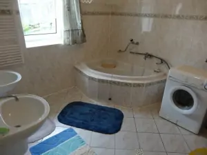 prostorná koupelna s rohovou vanou, sprchovým koutem, pračkou a 2 umyvadly