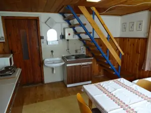 z kuchyně vedou schody do otevřené podkrovní ložnice