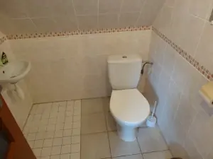 koupelna v podkroví je vybavena ruční sprchou, umyvadlem a WC