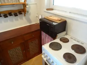 kuchyňka je vybavena pro vaření 4 osob (el. sporák na fotografii byl vyměněn za sklokeramický 2-plotýnkový el. vařič a el. troubu)