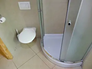 koupelna se sprchovým koutem, WC, umyvadlem a pračkou v přízemí
