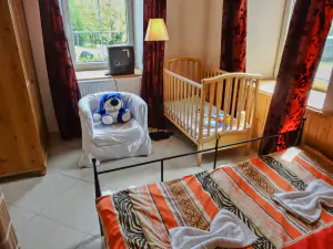 ložnice s dvojlůžkem a dětskou postýlkou v přízemí