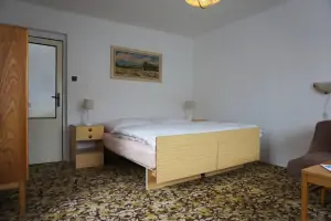 ložnice s dvojlůžkem, gaučem a TV