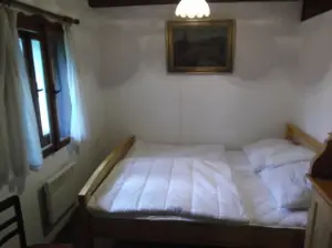 ložnice s dvojlůžkem v přízemí (od obytného pokoje je oddělena závěsem)