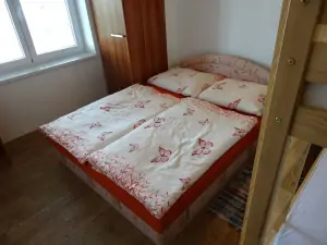ložnice s dvojlůžkem a patrovou postelí