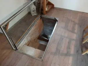 z obytné místnoti vedou schody do malého sklípku s posezením