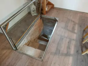 z obytné místnoti vedou schody do malého sklípku s posezením