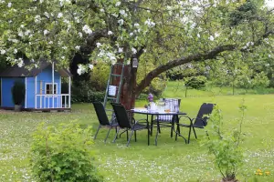 venkovní posezení na zahradě a za ním domeček pro děti