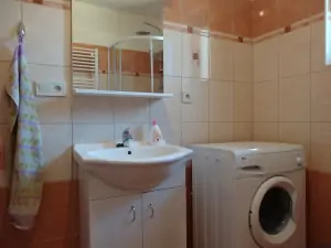 2. část chalupy - koupelna se sprchovým koutem, WC, umyvadlem a pračkou v přízemí
