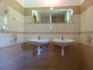 koupelna se sprchovým koutem a 2 umyvadly v podkroví