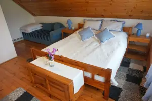 ložnice s dvojlůžkem a rozkládací postelí pro 2 osoby v podkroví