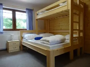 ložnice s patrovou postelí pro 3 osoby a dětskou postýlkou v přízemí