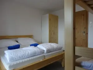 ložnice s dvojlůžkem a patrovou postelí v podkroví