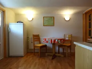 lednička, stůl a 2 židle v kuchyni