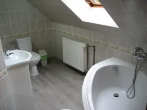 koupelna u ložnice v přízemí s rohovou vanou, WC a umyvadlem