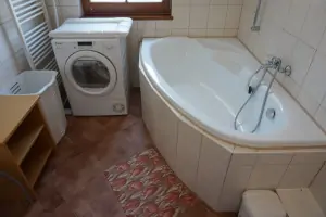 koupelna s rohovou vanou a umyvadlem (pračka na fotografii není k dispozici)